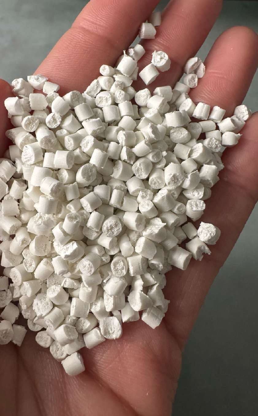 Pellets blancos cilíndricos en la palma de una mano